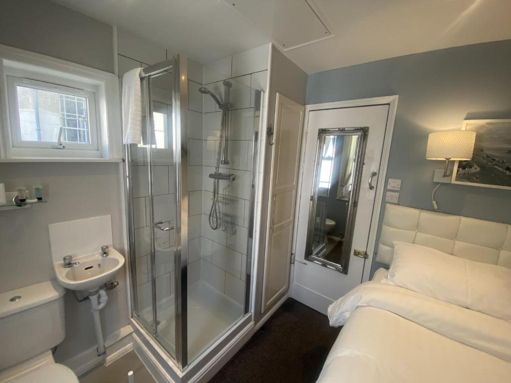 布莱顿霍夫Blue Sky Guest House的带淋浴、床和盥洗盆的浴室