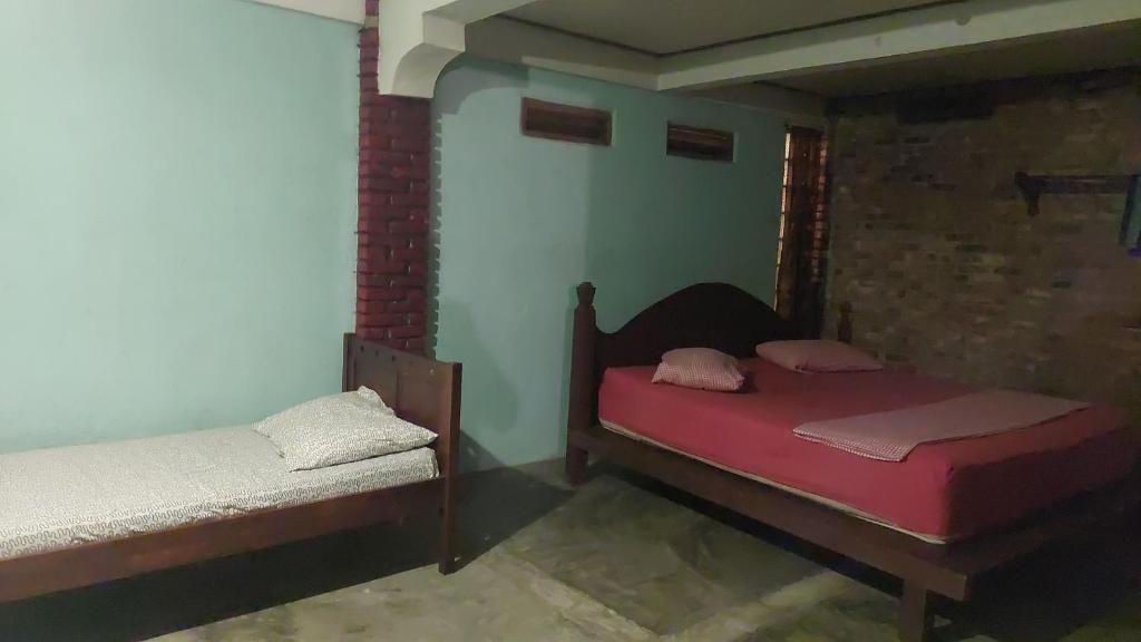 武吉拉旺Lawang Inn的一间卧室,配有两张床