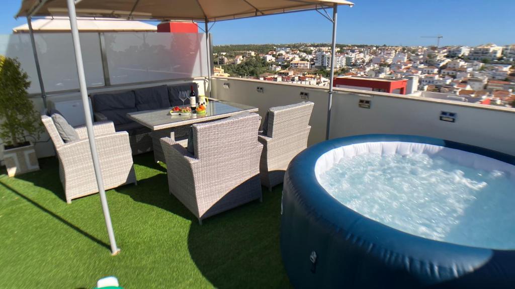 费拉古多Apartment Beta - 2 Bedrooms, Private Rooftop Patio with Hot Tub, BBQ and View的阳台设有游泳池、椅子和遮阳伞。