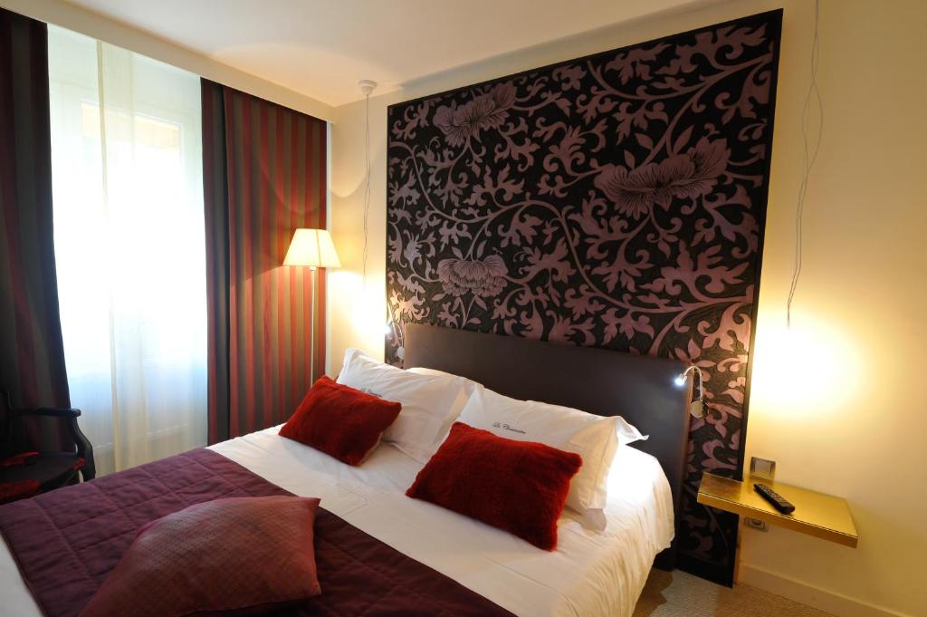 多勒Hotel La Chaumiere的一间卧室配有一张带两个红色枕头的床
