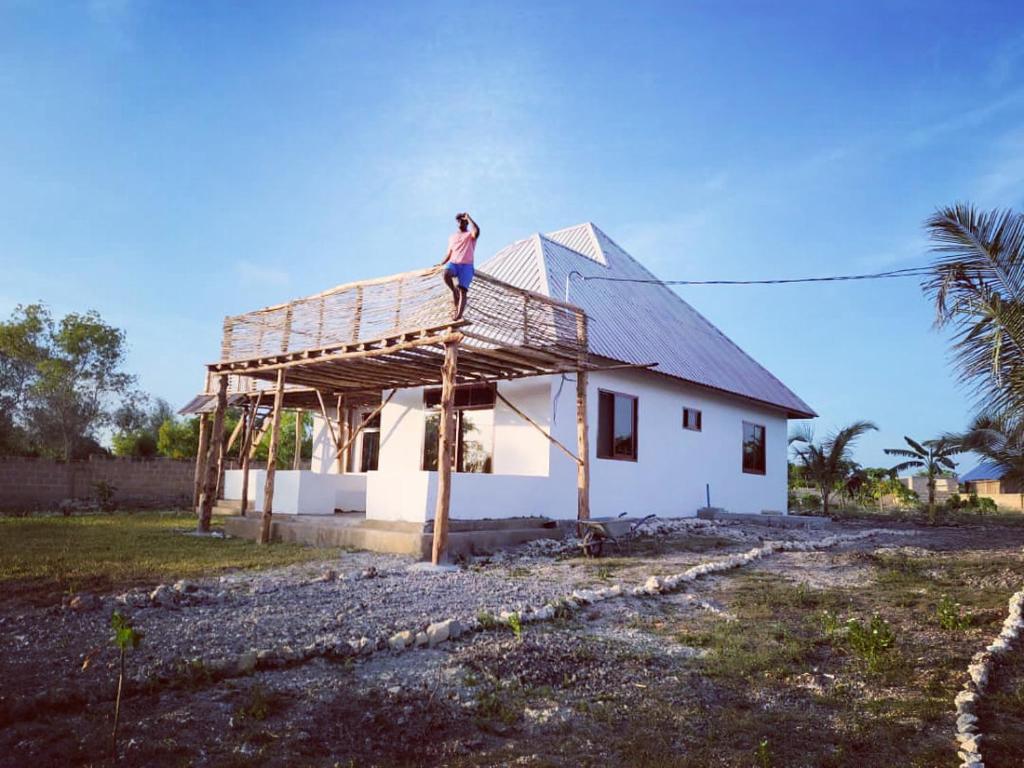基济姆卡济Villa Pumziko的站在房子屋顶上的男人
