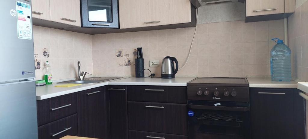 尼古拉耶夫Проспект Центральный 6-я слободская的厨房配有黑色橱柜和炉灶烤箱。