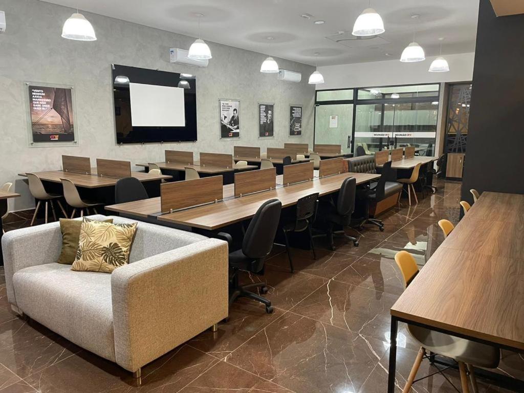 索罗卡巴Flat Aconchegante的一间会议室,配有桌椅和沙发