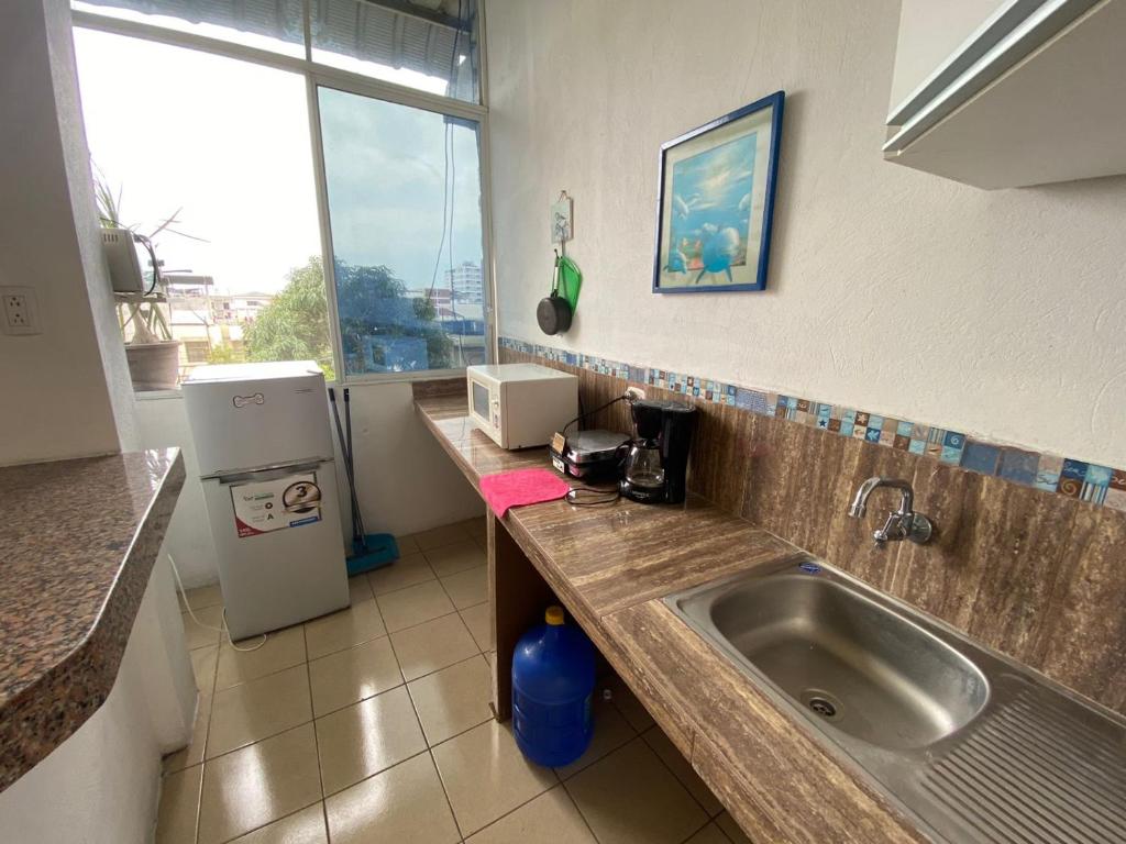 曼塔Playa Aparts & Suites Malecon的厨房配有水槽和冰箱