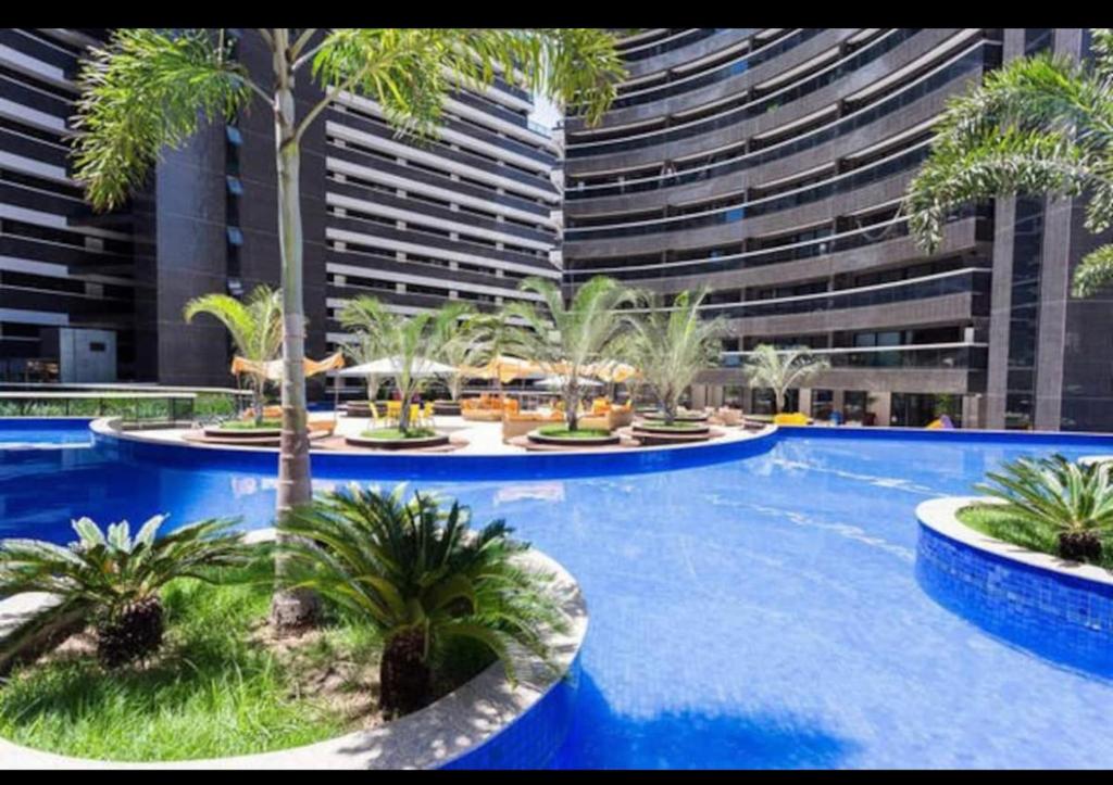 福塔莱萨Fortaleza Landscape Beira-mar: espaço inteiro的一座棕榈树游泳池和一座大型建筑