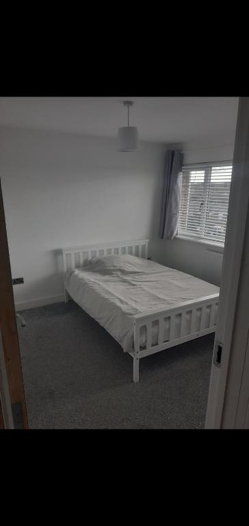 克劳利Short and Long Night Stay - very close to Gatwick and City Centre - Private Airport Holiday Parking - Early Late Check-ins的卧室位于客房的角落,配有一张床