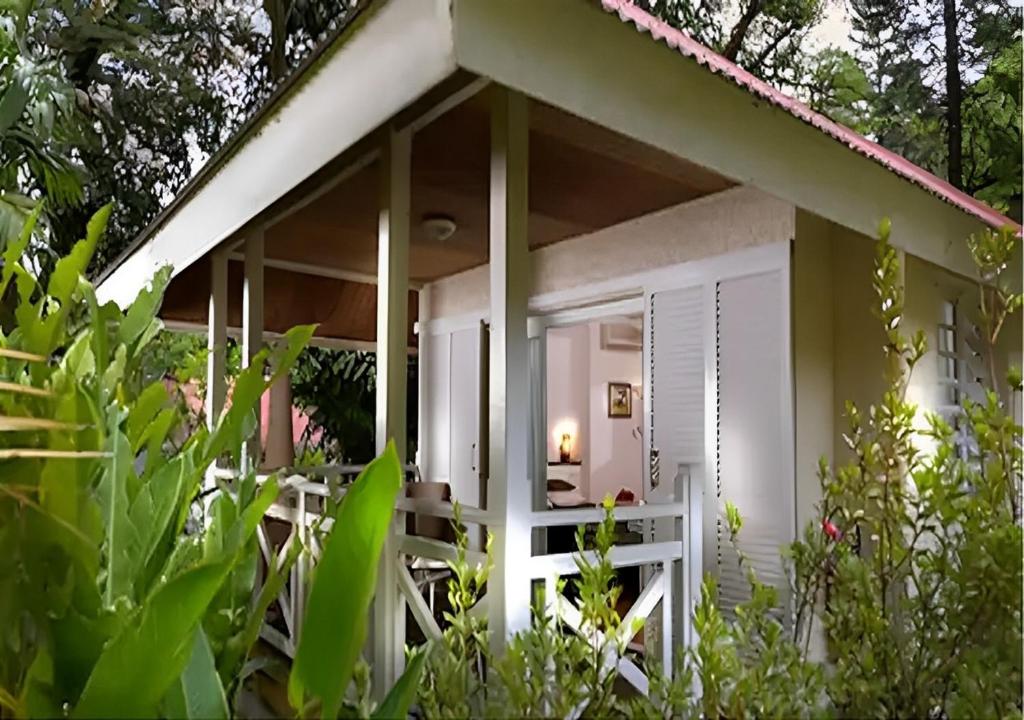 SarraméaEVASION Bungalow Tropical Spa的白色的房子,有门廊和一些植物
