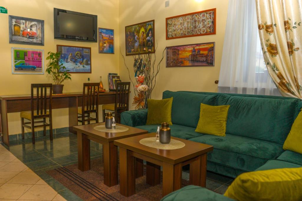 克鲁舍瓦茨Garni Hotel City的客厅配有绿色沙发和桌子