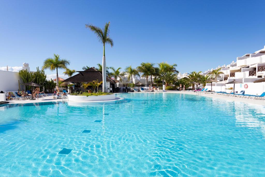帕莱索海滩apartamento paradise luxury的棕榈树度假村的大型游泳池