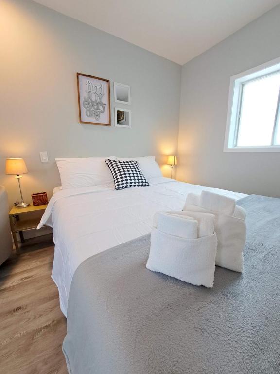 圣安娜德博普雷Habitations Zenith的一间白色卧室,配有两张床和窗户