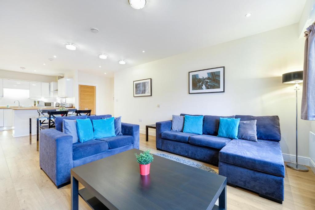 梅登黑德Spacious Luxury 3 Bed Apt W Parking by 360Stays的客厅配有蓝色的沙发和桌子