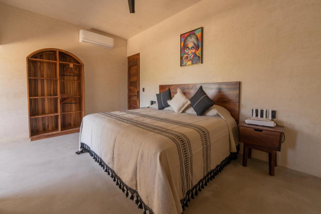 Brisas de ZicatelaCasa Mava的一间卧室配有一张床和一张桌子及床头柜