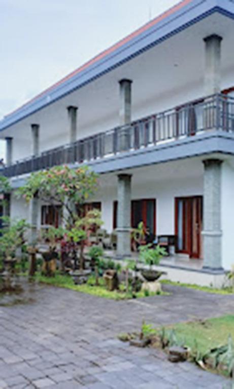 沙努尔LA Homestay sanur的一座白色的大建筑,前面设有一个庭院