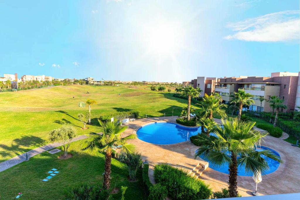 马拉喀什Cozy Golf Apartment Wifi 4k-TV Netflix的享有度假村的空中景致,设有游泳池和棕榈树