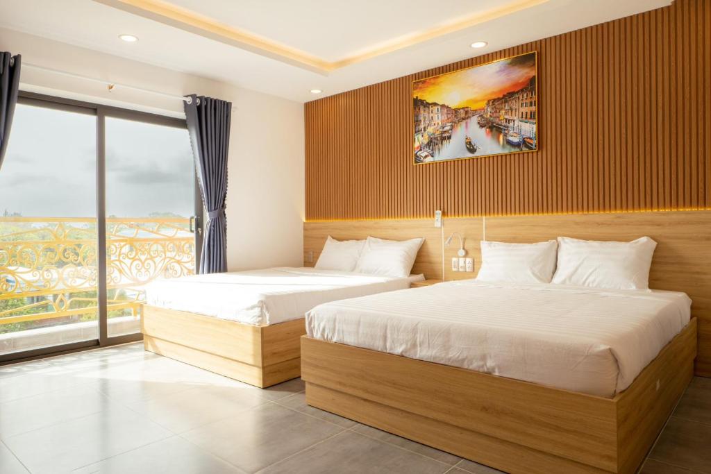 昆岛Ngọc Anh Hotel的酒店客房设有两张床和窗户。