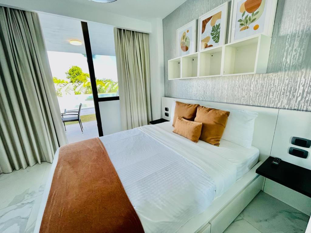 蓬塔卡纳Cana Rock Star luxury condo, Casino, golf, beach in Hard Rock área的一间卧室配有带枕头的床铺和阳台