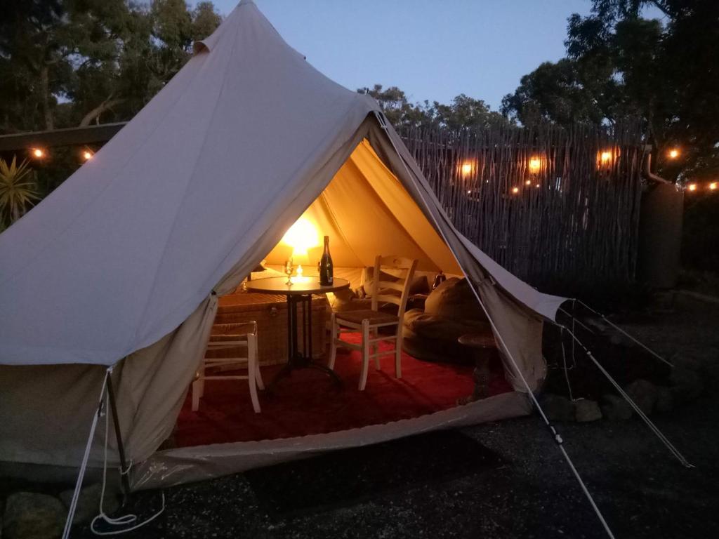 马其顿Macedon Ranges Glamping的庭院内带桌椅的帐篷