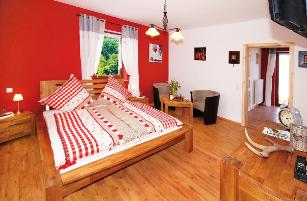 HallgartenGästezimmer Hans-Norbert Mack的一间卧室设有一张带红色墙壁的大床