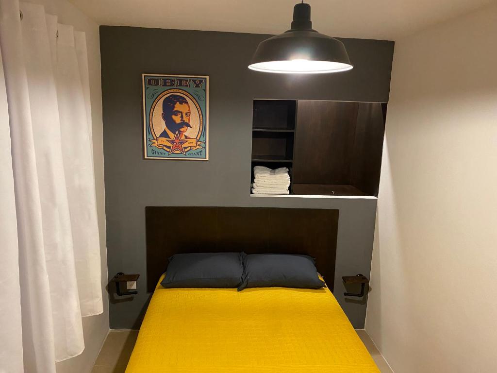 墨西哥城Cozy Condesa的一间卧室配有一张黄色毯子床