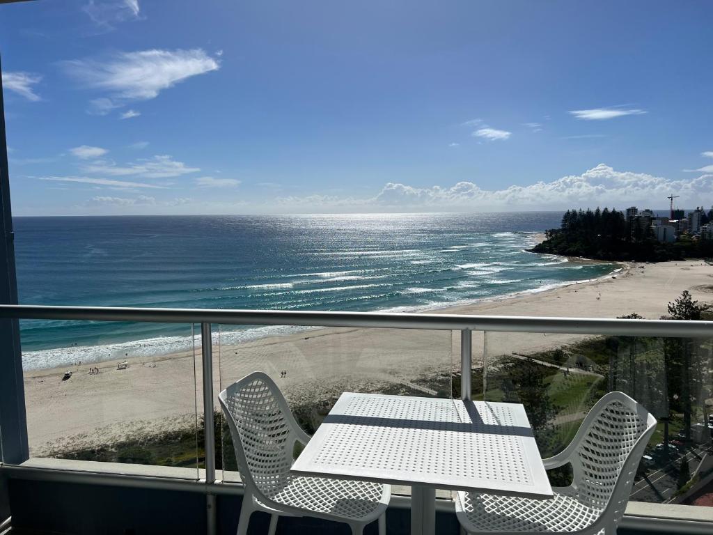 黄金海岸Endless Summer in Cooly Level 18的一个带桌椅和海滩的阳台