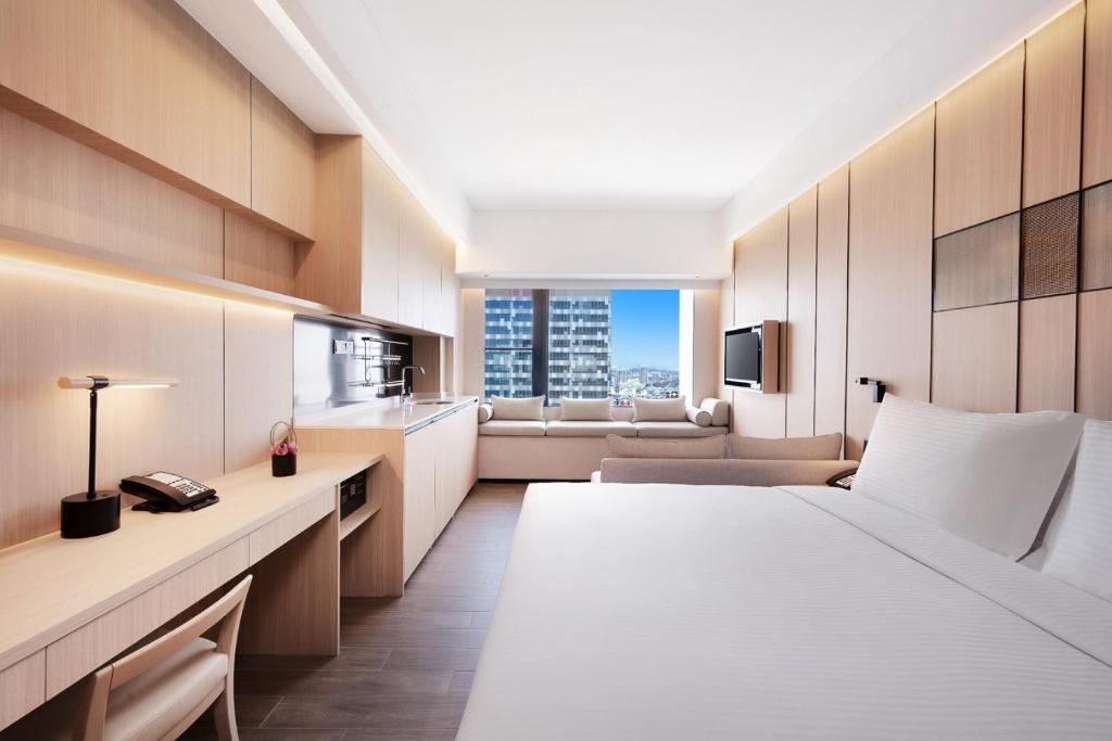 上海大都会海逸公寓的酒店客房,配有床和沙发
