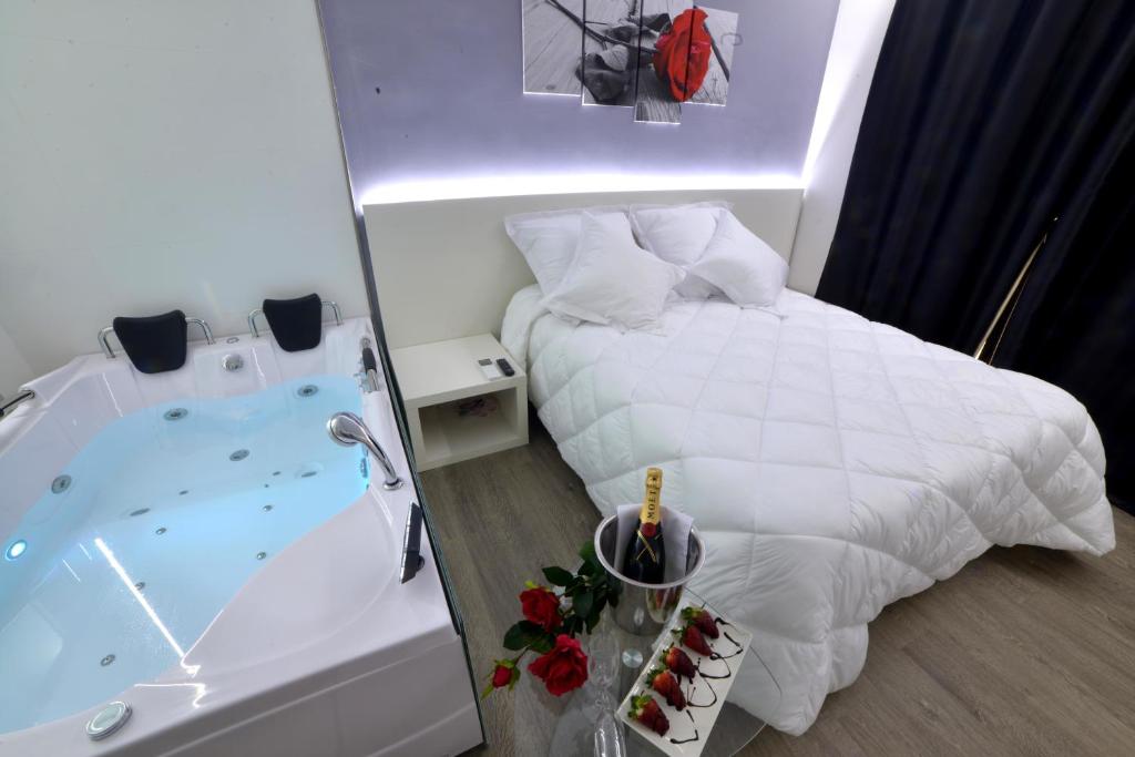 阿尔卡拉德尔胡卡尔阿尔卡拉胡卡佩拉约酒店的浴室设有浴缸,位于床边,配有床和浴缸。