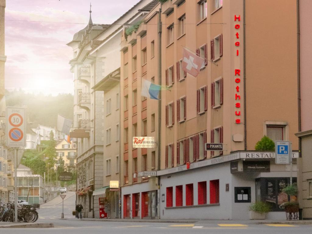 卢塞恩Hotel Rothaus Luzern & Peruvian Culinary Art的城市街道上带有红色门的建筑