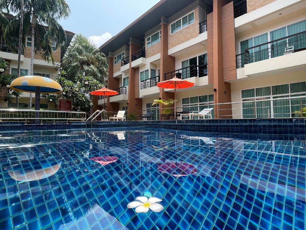 卡塔海滩Thalassa pool Kata Beach的游泳池位于酒店前,配有遮阳伞