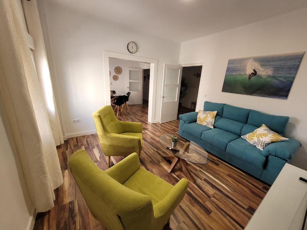 加的斯La Playita Santa María Beach的客厅配有蓝色沙发和2把绿色椅子