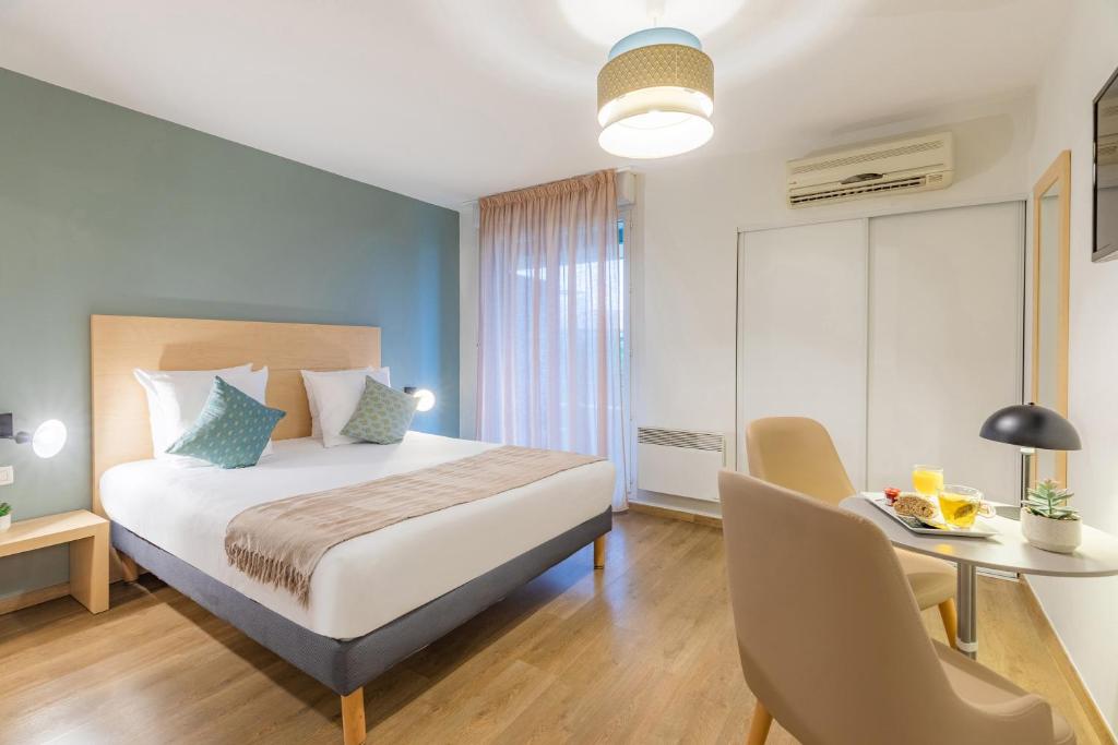图卢兹Appart'City Confort Toulouse Purpan的卧室配有一张床和一张桌子及椅子
