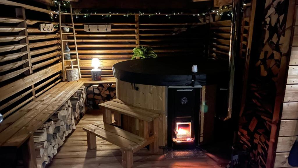 克松吕-隆日梅※ Résidence POMME DE PIN - Terrasse - Nature ※的一个带长凳的客房内的燃木炉