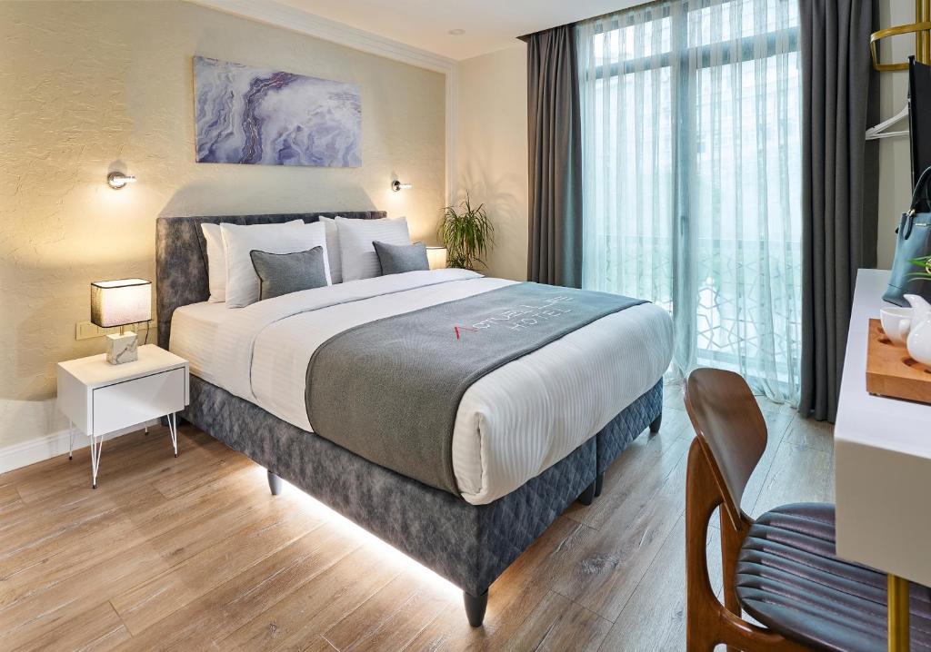 伊斯坦布尔ACTUEL LİFE HOTEL的一间卧室设有一张大床和一个大窗户