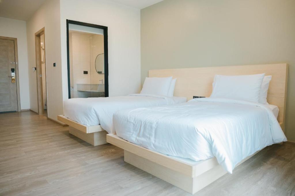 Ban Ko RianMayuu Ayutthaya Hotel的一间卧室配有两张带白色床单和镜子的床