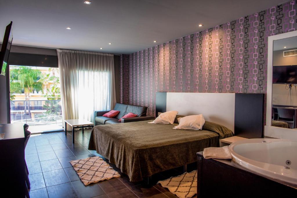 罗列特海岸Hotel Acacias Suites & Spa的酒店客房配有一张床和浴缸。