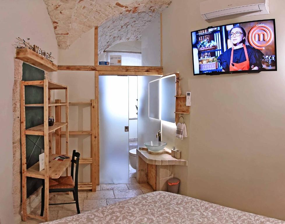 普蒂尼亚诺l'angolo di Gaudì, alcoba Blanca的卧室配有一张床,墙上配有电视。
