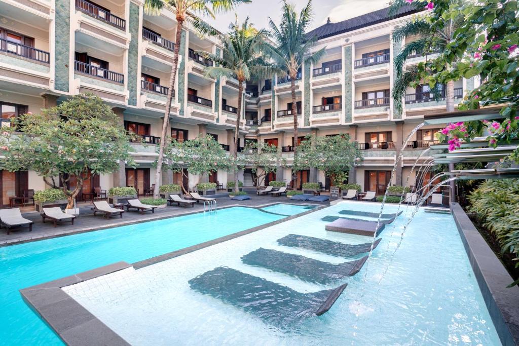库塔维拉巴厘岛精品酒店及套房的一座建筑的庭院中的游泳池
