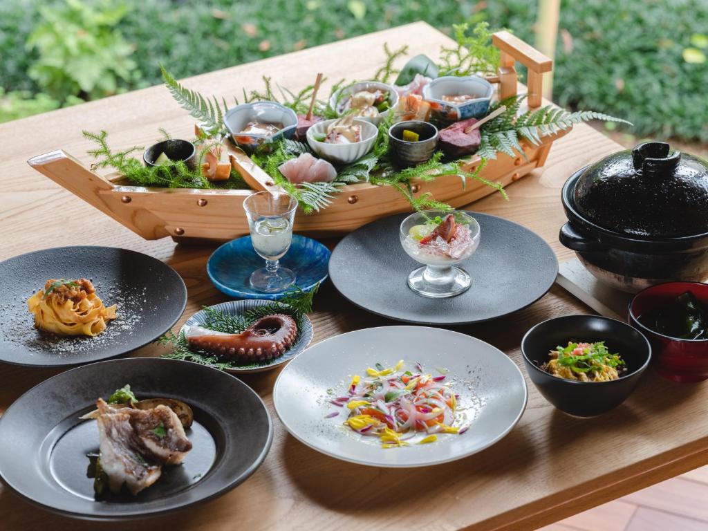 小滨市sea-auberge shitsumi 海のオーベルジュ志積的一张木桌,上面放着食物盘