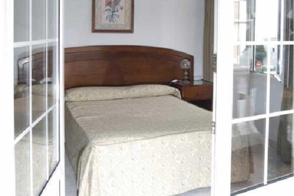 巴尔韦尔德回力镖酒店的一张卧室的两张照片,卧室里有一张床