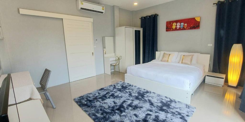 邦涛海滩Patrick villa phuket的一间卧室配有一张床和一张带地毯的书桌