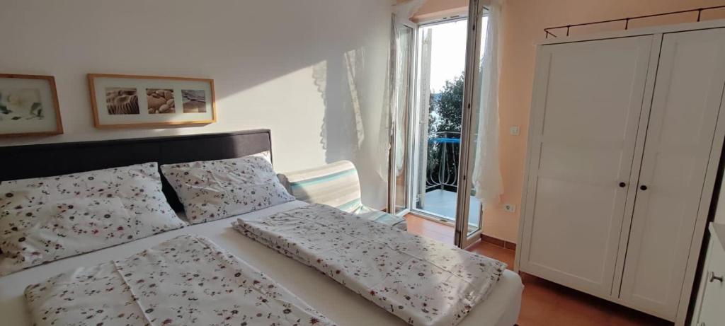 茨里克韦尼察Ivana apartman 3的卧室配有带枕头的床铺和窗户。