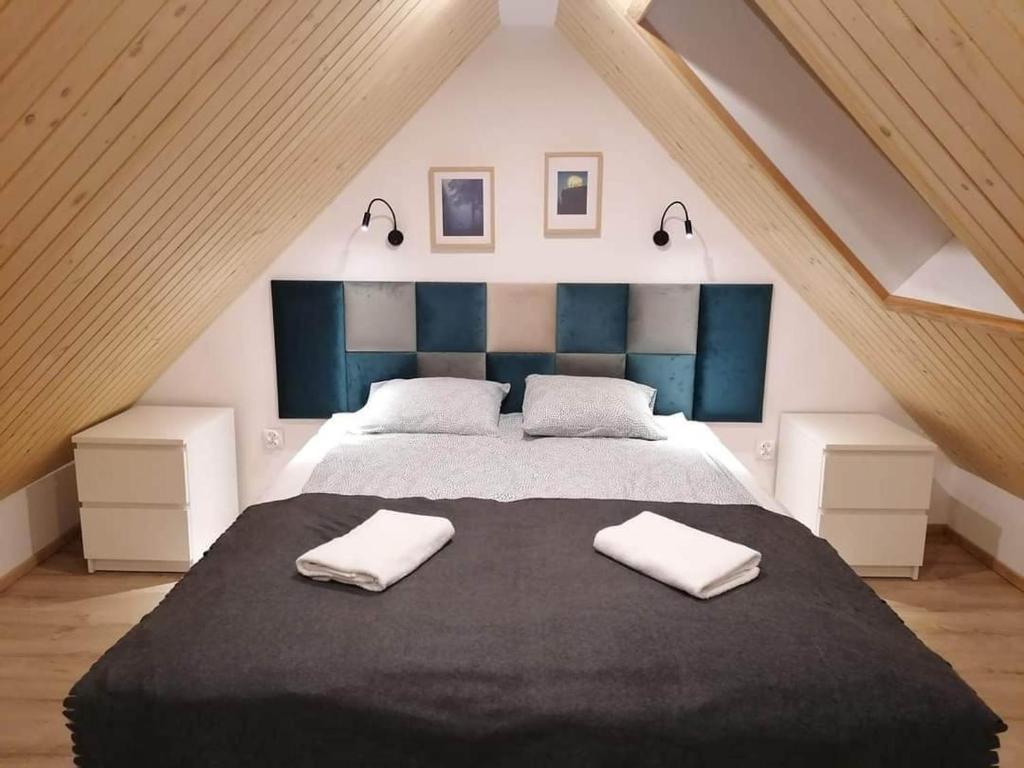 杜什尼基-兹德鲁伊Stara Kuźnia的一间卧室配有一张大床和两条毛巾