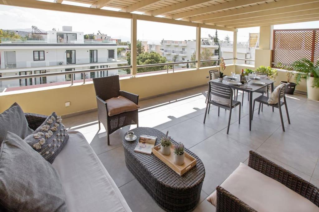 瓦里Sea view penthouse in Vari的客厅配有沙发和阳台桌子