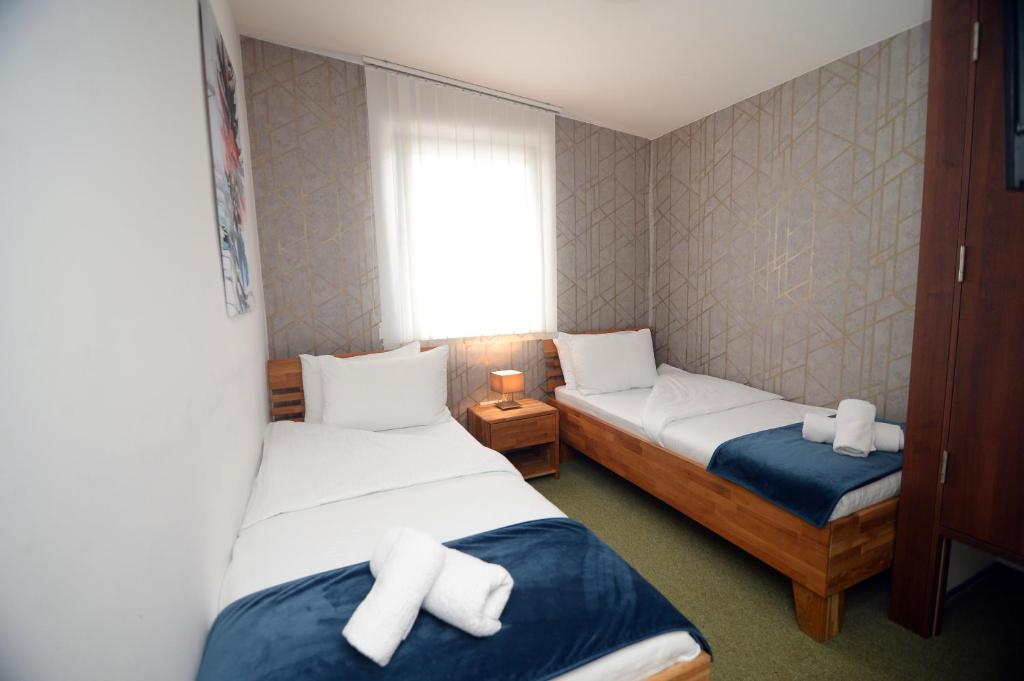 LučaniApartmani Čarolija的小房间设有两张床和窗户