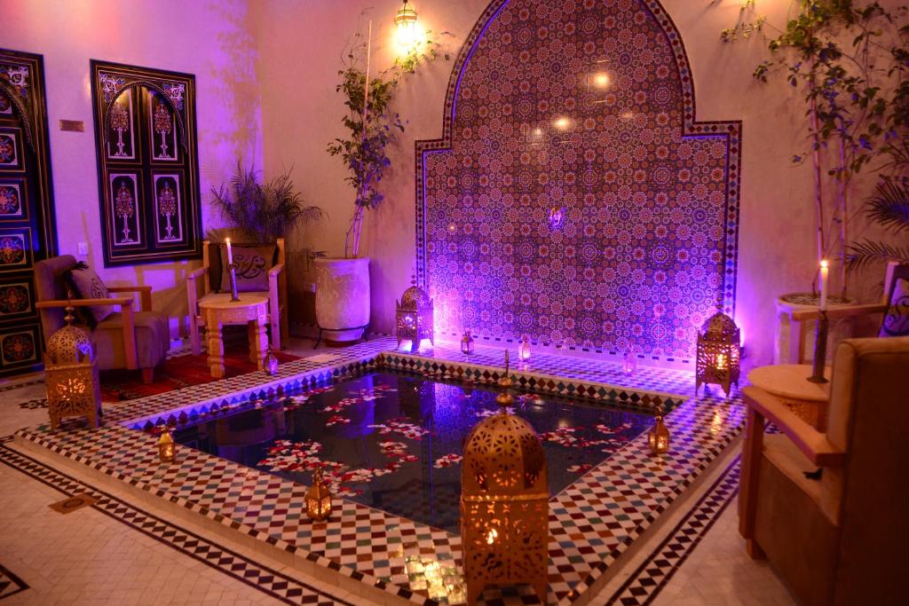 马拉喀什Riad Bab Nour的紫色灯的房子里的一个游泳池
