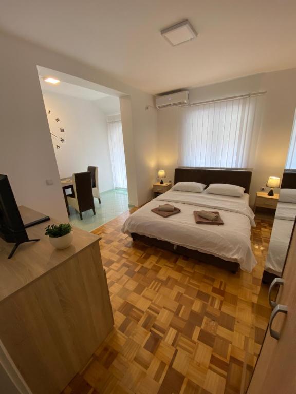 索科矿泉村Apartmani Milojić的一间卧室设有一张大床,铺有木地板