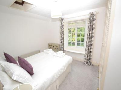 文特诺Quince Cottage的白色的卧室设有床和窗户