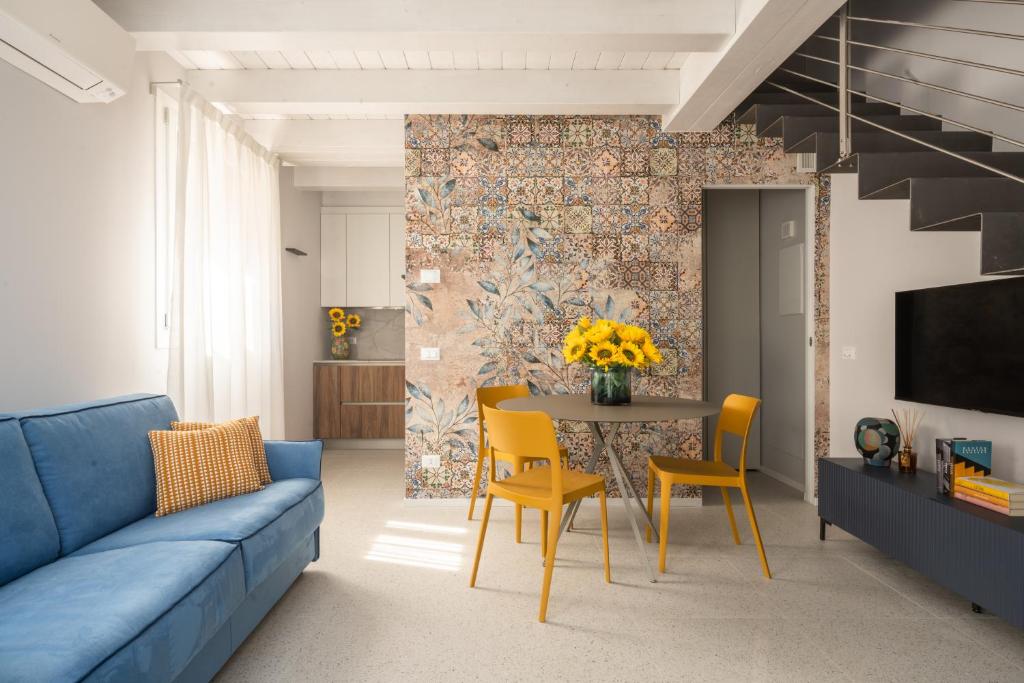 威尼斯Fondamenta de la Sensa Garden Loft R&R的客厅设有蓝色的沙发和带黄色椅子的桌子