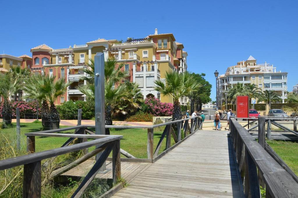 韦尔瓦Luxury Apartment in Marina de Isla Canela- Beach Front的木板人行道,在一些建筑前