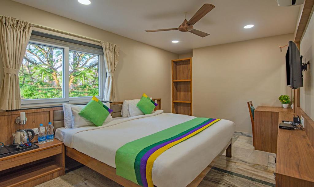 贾姆谢德布尔Treebo Trend Gyani's的一间卧室设有一张大床和一个窗户。
