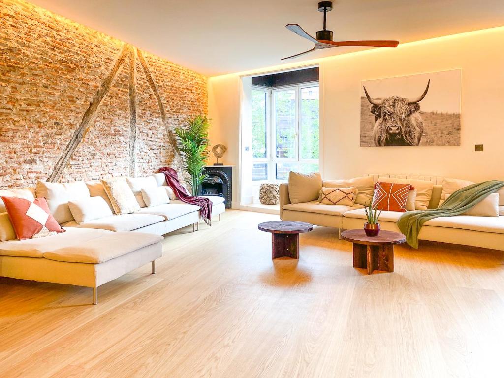 毕尔巴鄂Ribera AC by Staynnapartments的客厅设有两张沙发和砖墙